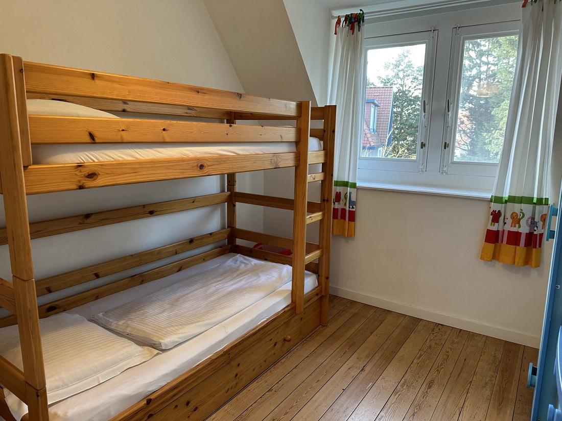 Slaapkamer 3, een kinderkamer met een houten stapelbed.