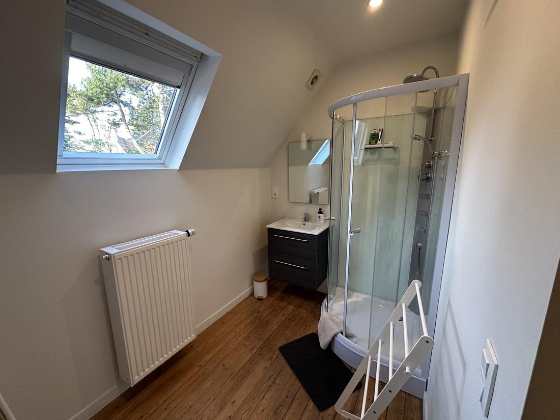 Eigen badkamer met een gebogen glazen douchecabine.
