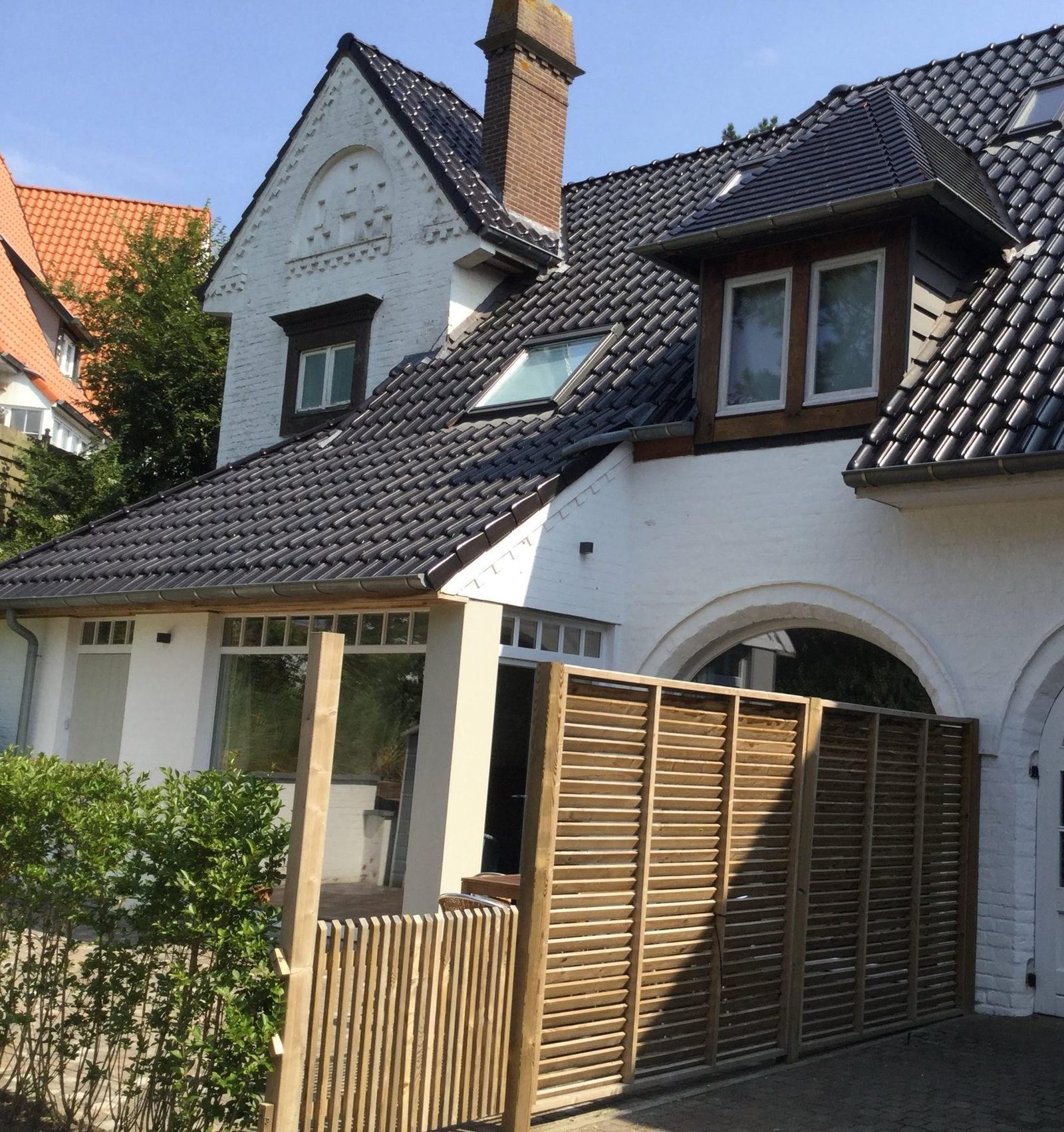 Het huis uit 1935 in De Haan, met zijn donkere pannendaken en de houten poort naar de privé-ingang van Ons Nest.